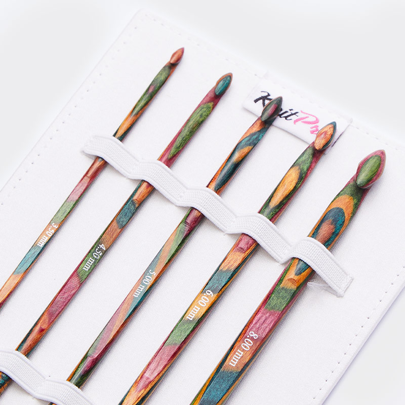 Conjunto de agulhas de tricot coloridas em suporte branco