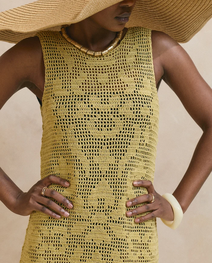 Top de malha amarelo em crochet com padrão geométrico e acessórios de verão