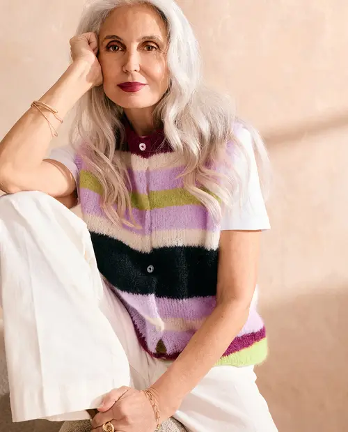 Camisola de malha às riscas multicolor usada por mulher com calças brancas