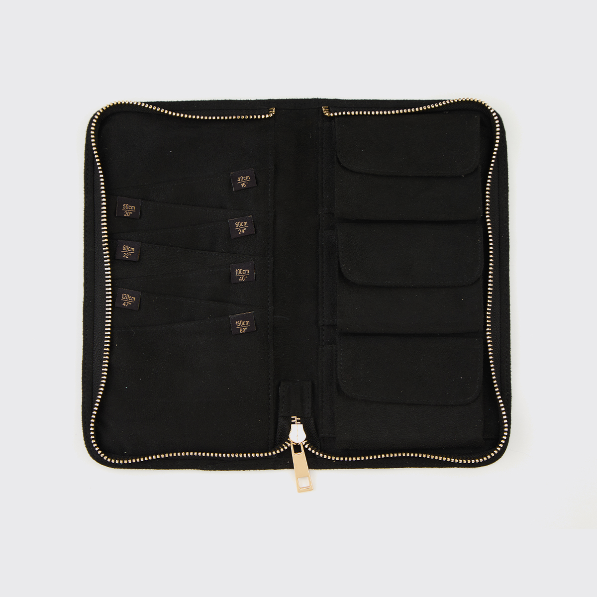 Organizador preto em tecido aberto com fecho dourado e bolsos internos