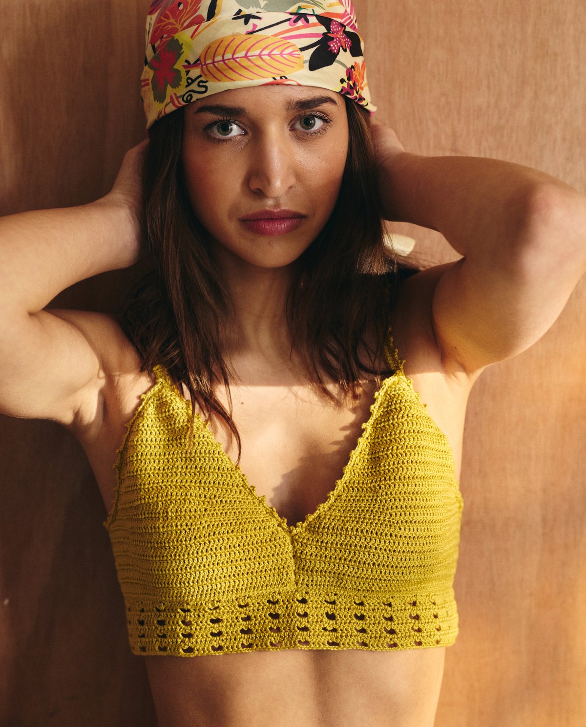 Top cropped amarelo em croché com alças finas e bandana estampada.