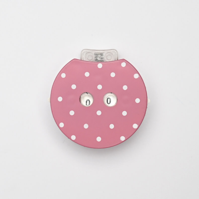 Medidor de fita métrica redondo cor-de-rosa com bolinhas brancas e botões metálicos