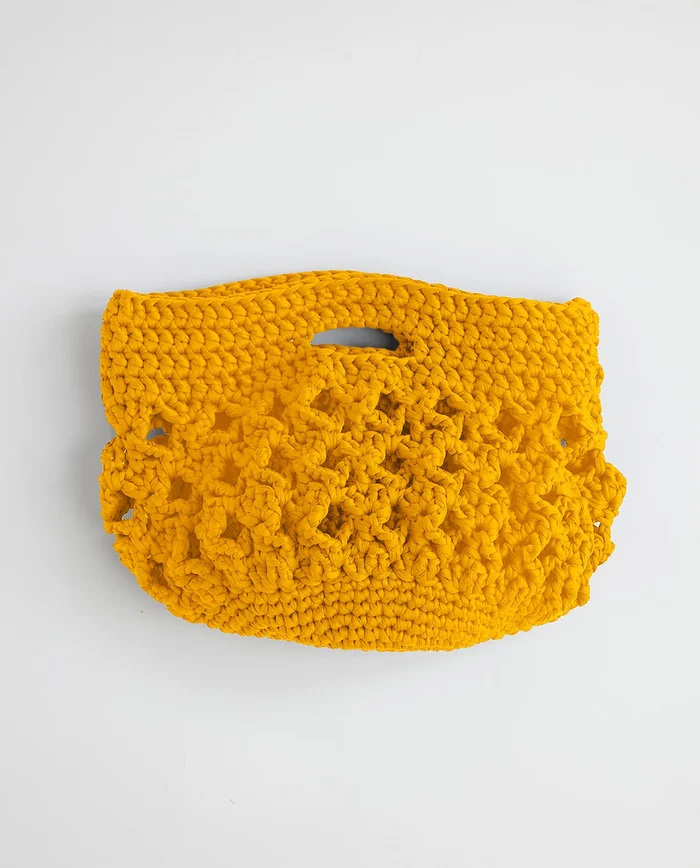 Mala de mão artesanal em crochet amarelo mostarda sobre fundo branco