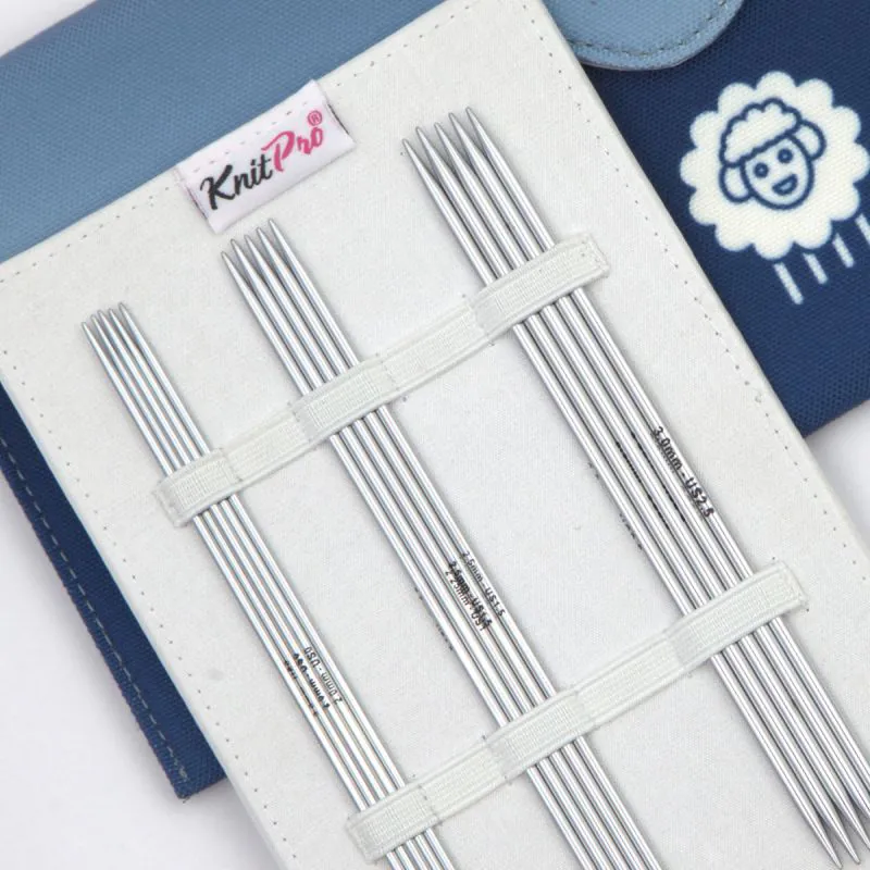 Agulhas de tricotagem metálicas com suporte branco e fundo azul com ícone de ovelha