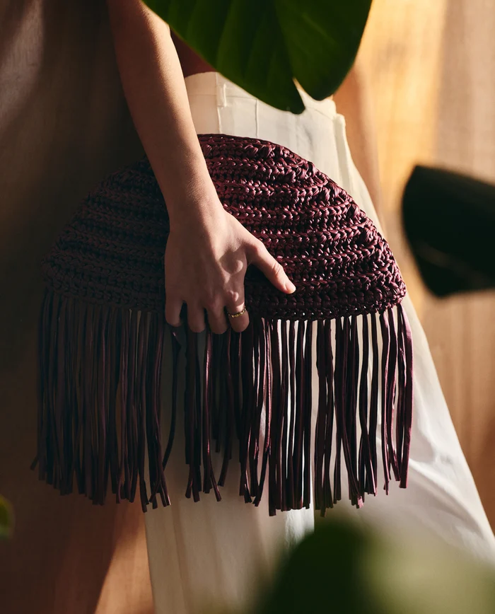 Mala de tricot castanha com franjas e calças brancas