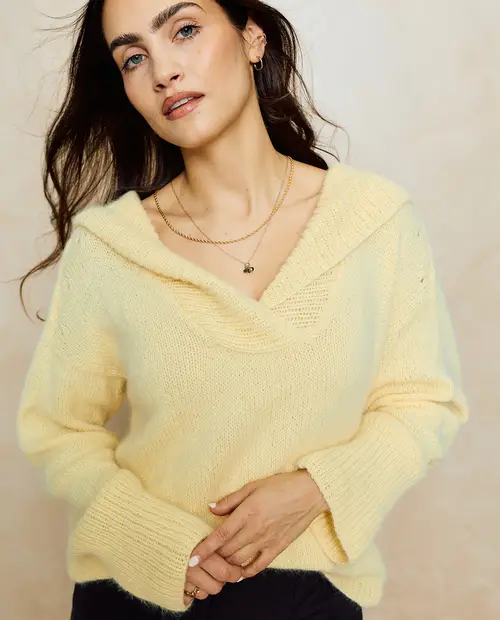 Mulher a usar suéter amarelo claro de malha com gola ampla