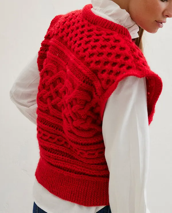 Colete vermelho de malha com padrão trançado e camisa branca