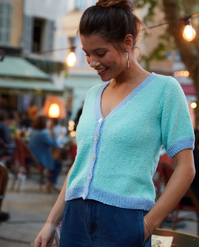 T-shirt de malha azul clara feminina com botões num ambiente urbano ao ar livre