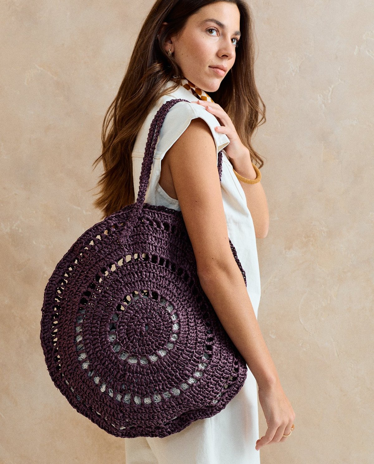 Mala de mão redonda roxa em croché com padrão circular