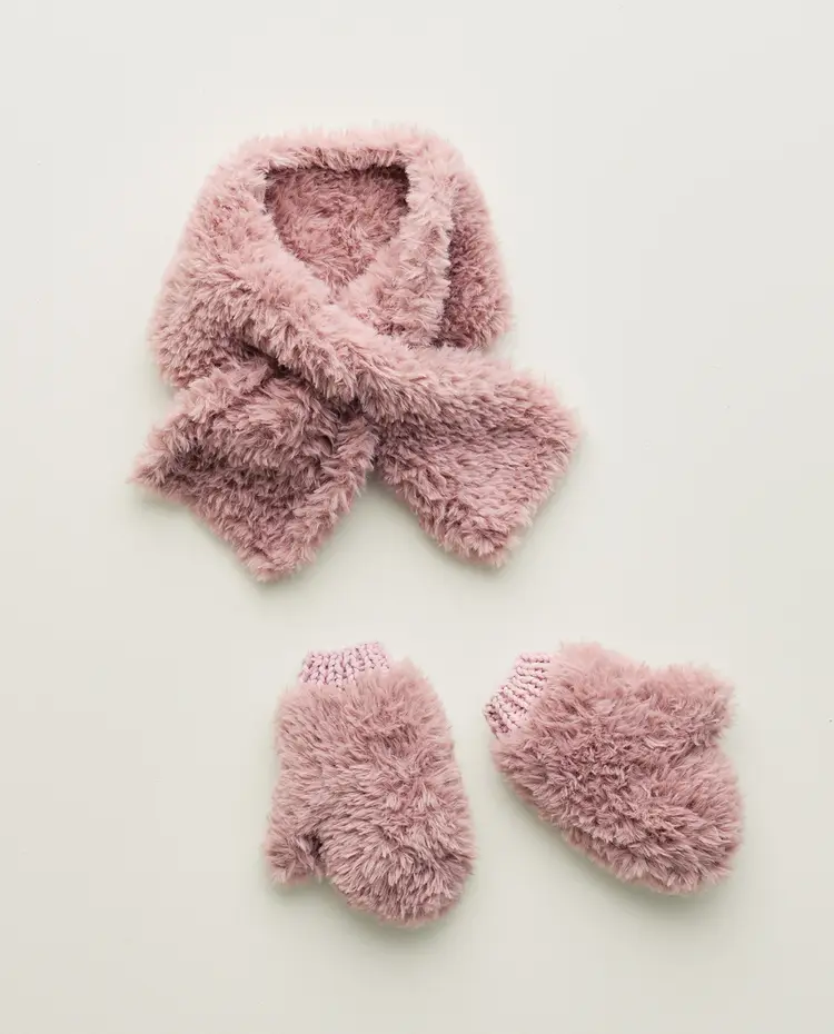Cachecol e luvas cor-de-rosa em tecido felpudo sobre fundo branco