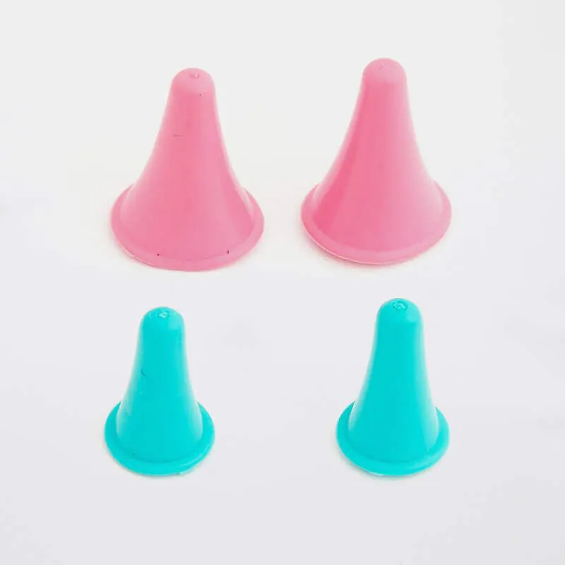 Quatro cones de treino pequenos, dois rosa e dois azuis, sobre fundo branco