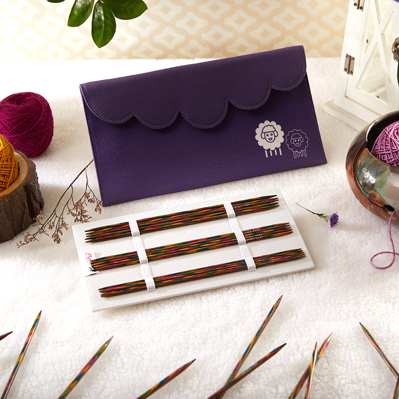 Conjunto de agulhas de tricô coloridas com bolsa roxa decorada com ovelhas