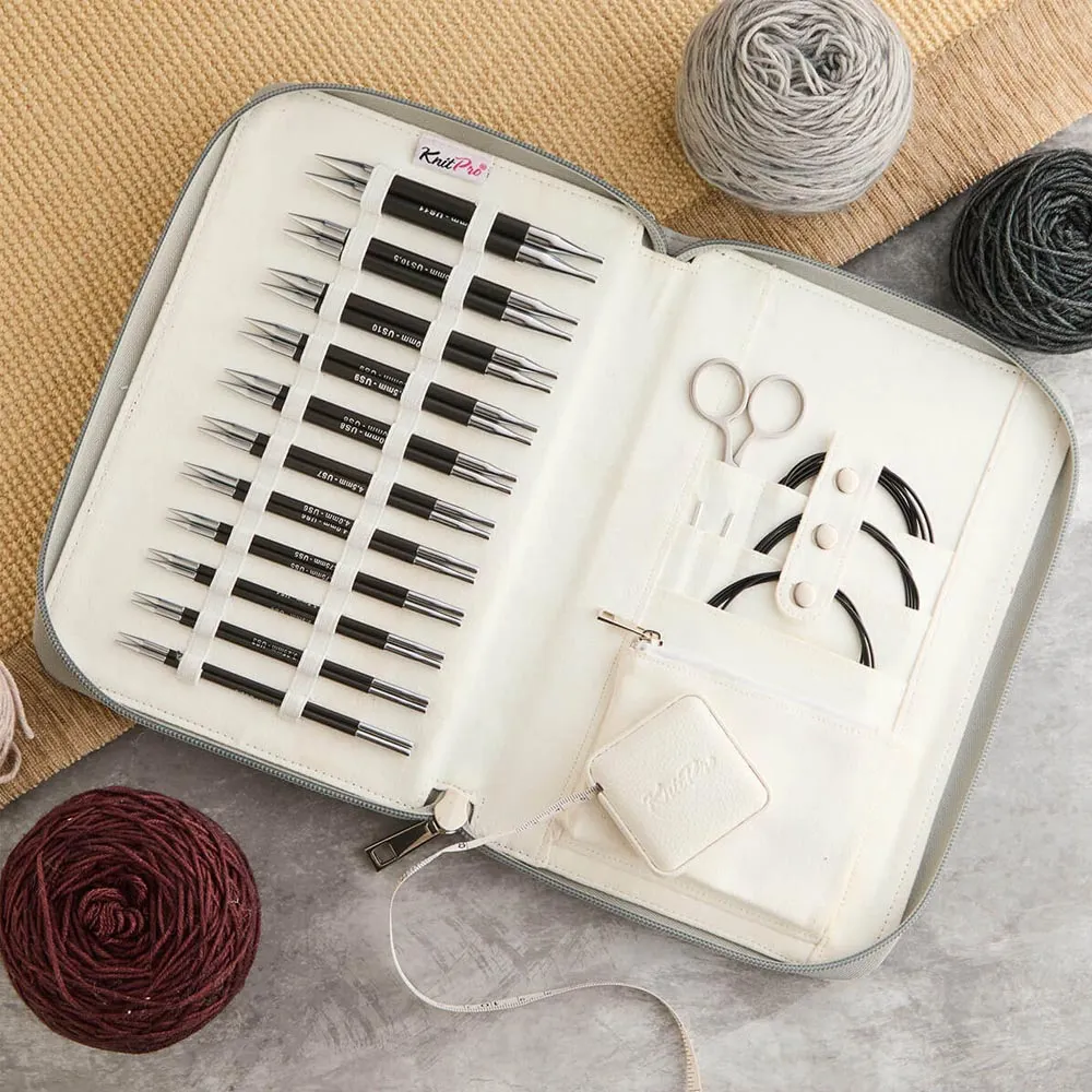 Estojo aberto com agulhas de tricô e acessórios rodeado de novelos de lã