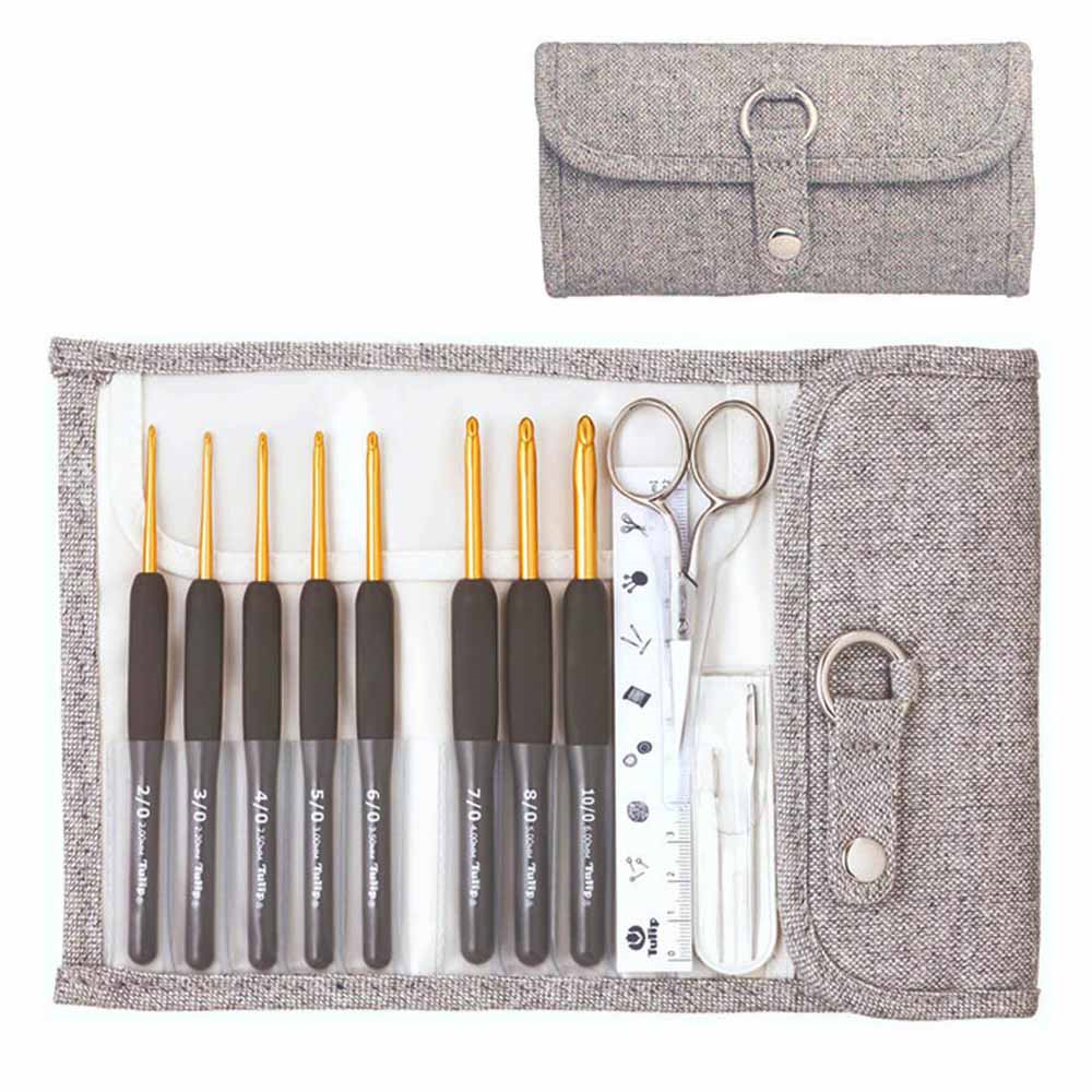 Conjunto de agulhas de crochet e acessórios numa carteira de tecido cinzento