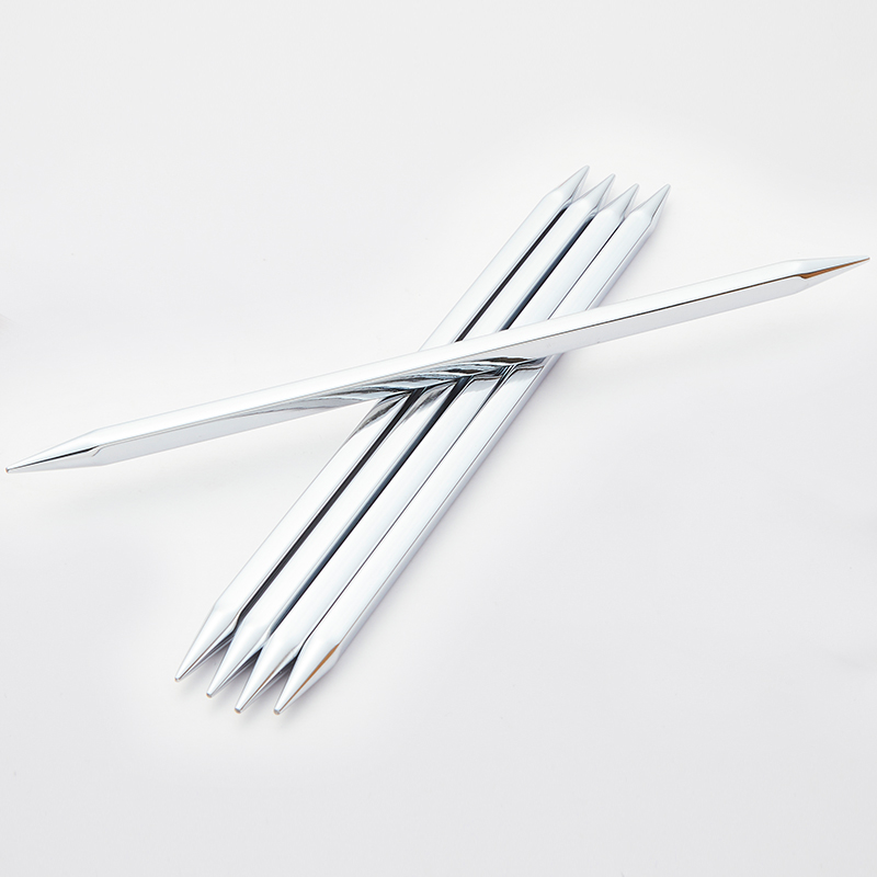 Seis agulhas de tricô metálicas brilhantes sobre fundo branco