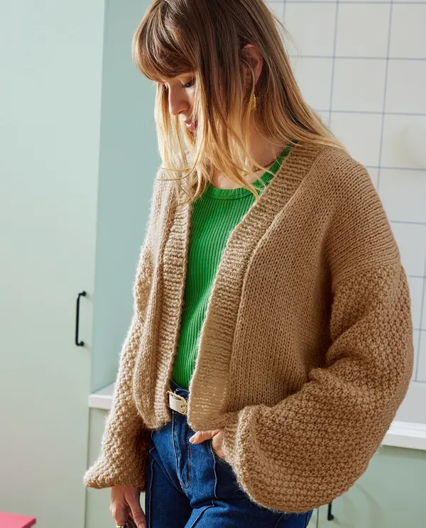 Cardigan de malha grossa castanho claro com camisola verde e calças de ganga