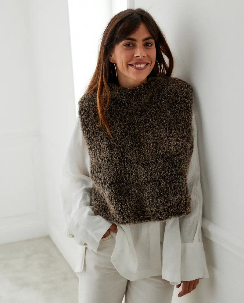 Mulher com camisola de malha castanha felpuda e camisa branca fluida