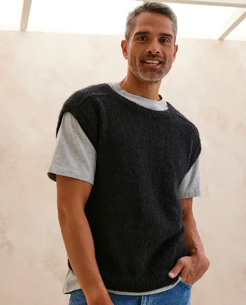 Homem com camisola preta de malha sem mangas e t-shirt cinzenta