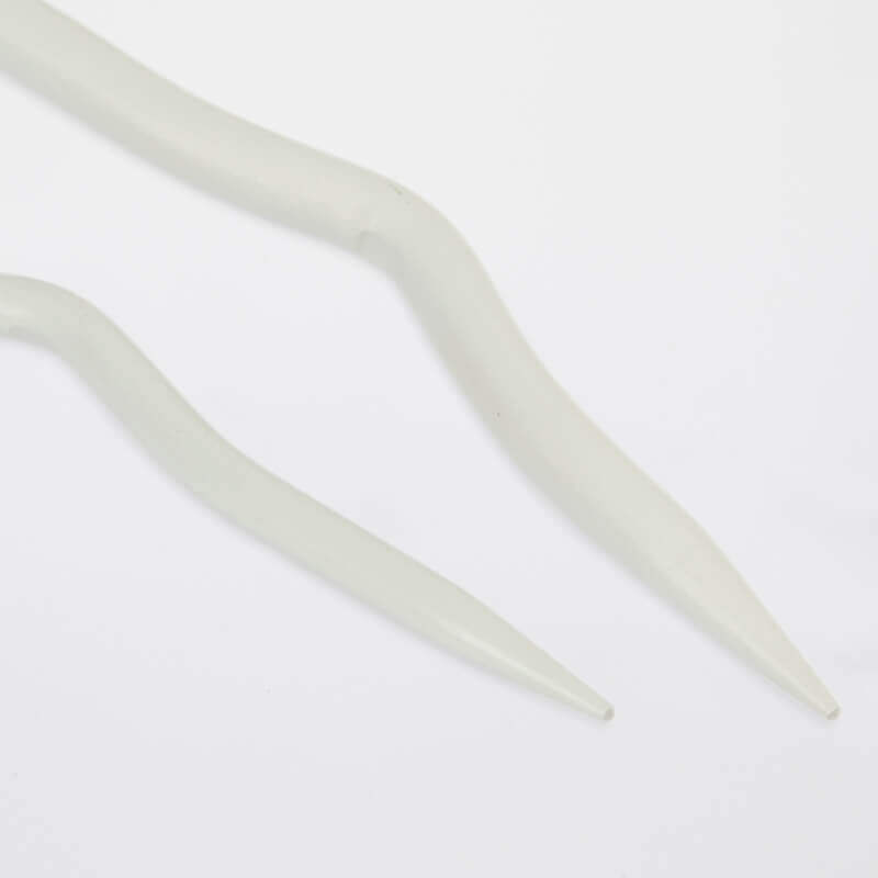 Duas agulhas de tricô brancas sobre fundo branco