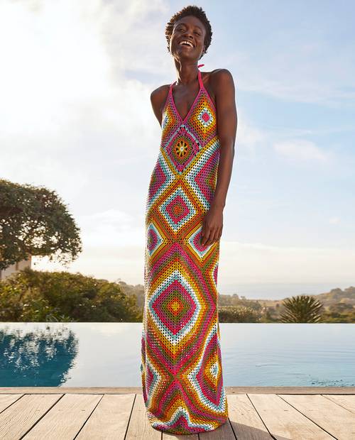 Vestido longo de crochet multicolorido com padrão geométrico usado por mulher à beira de piscina