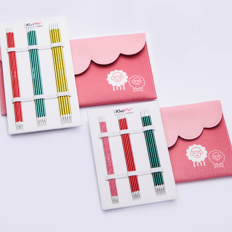 Conjunto colorido de agulhas de tricotar com capa rosa decorada com ovelhas brancas