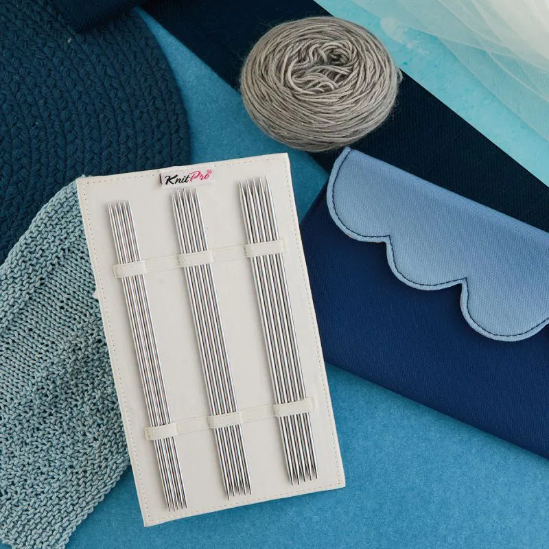 Agulhas de tricô KnitPro com novelo de lã cinza e estojo azul