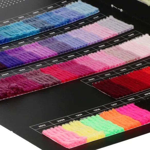 Mostruário de fios coloridos organizados por código sobre fundo preto