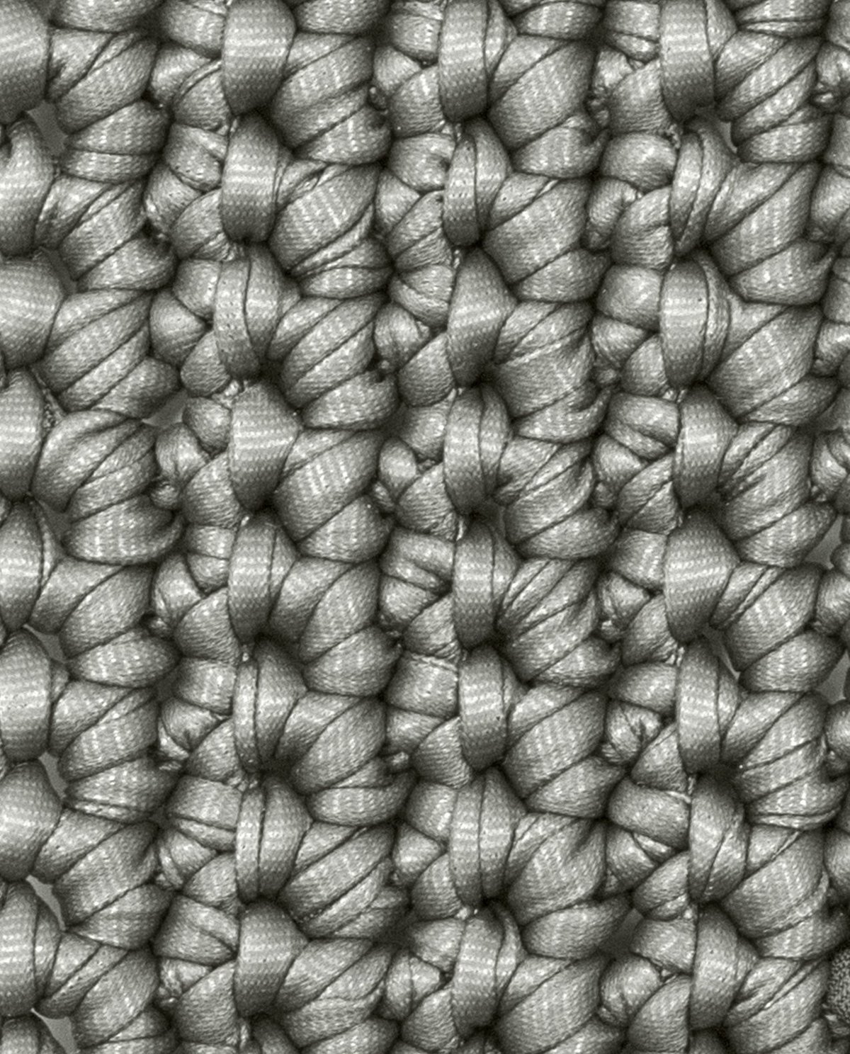 Tecido cinza tricotado com padrão de nós entrelaçados em detalhe.