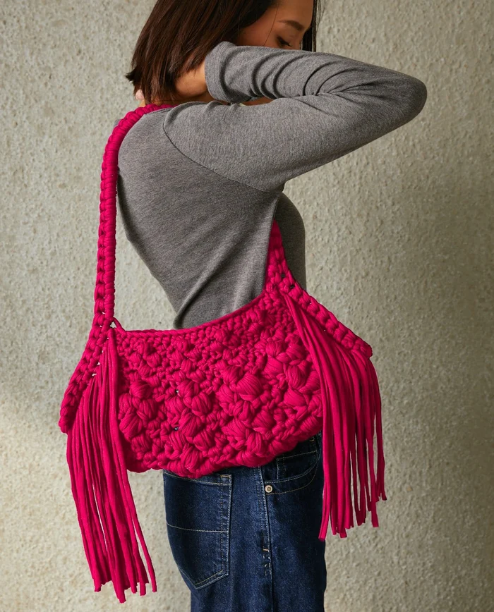 Mala rosa trançada com franjas longa usada ao ombro