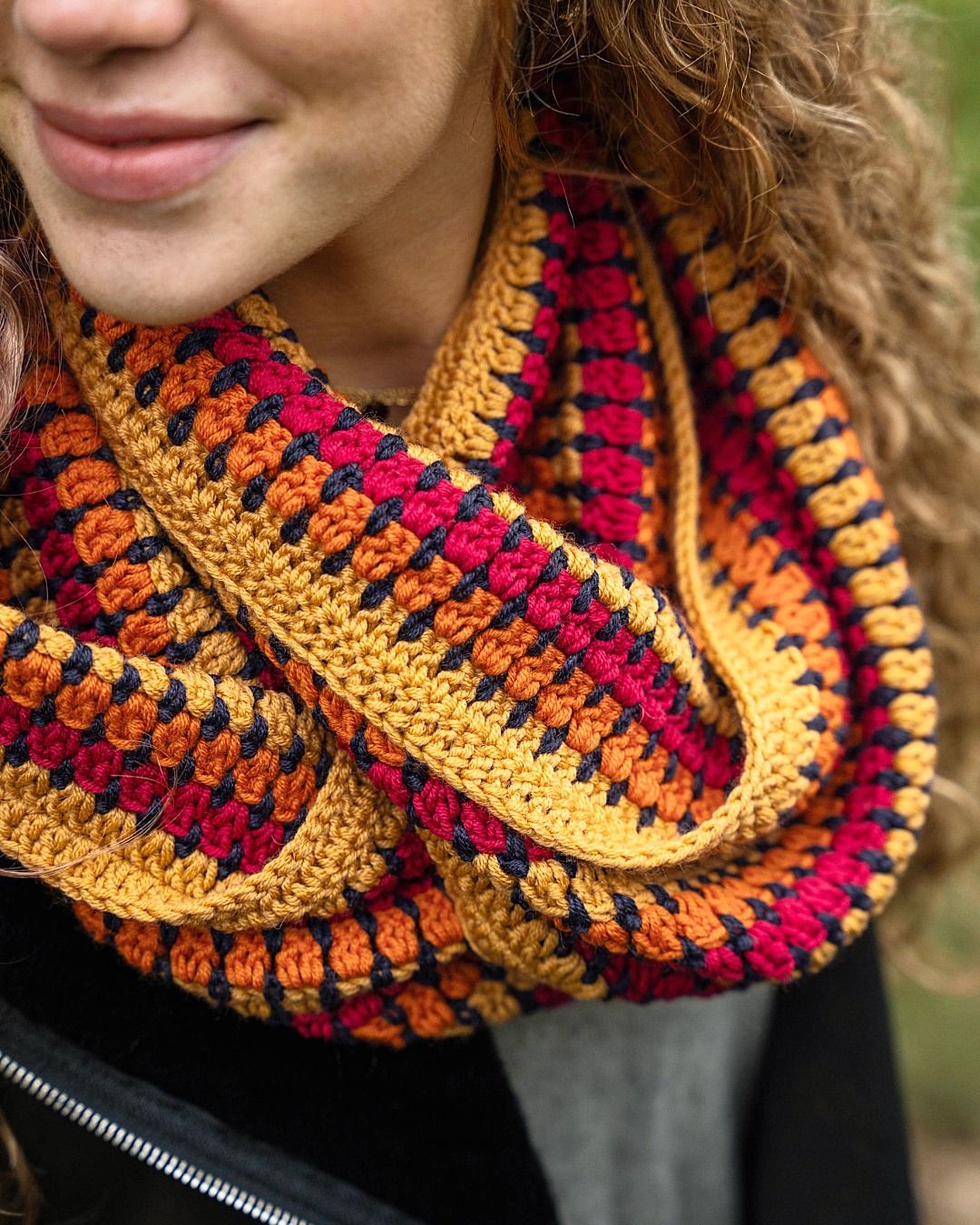 Cachecol em crochet com padrão colorido usado ao redor do pescoço