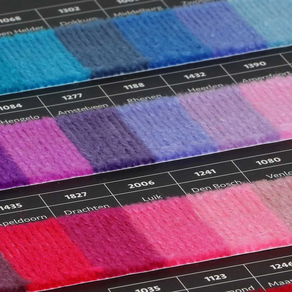 Amostras de fios de lã coloridos em tabelas pretas com números e nomes de cidades.