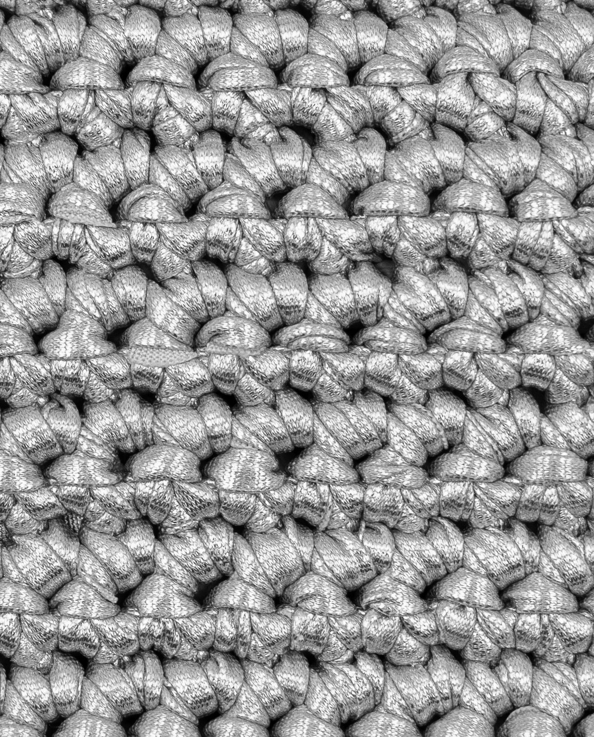 Malha grossa de fio prateado metálico entrelaçada em padrão repetido