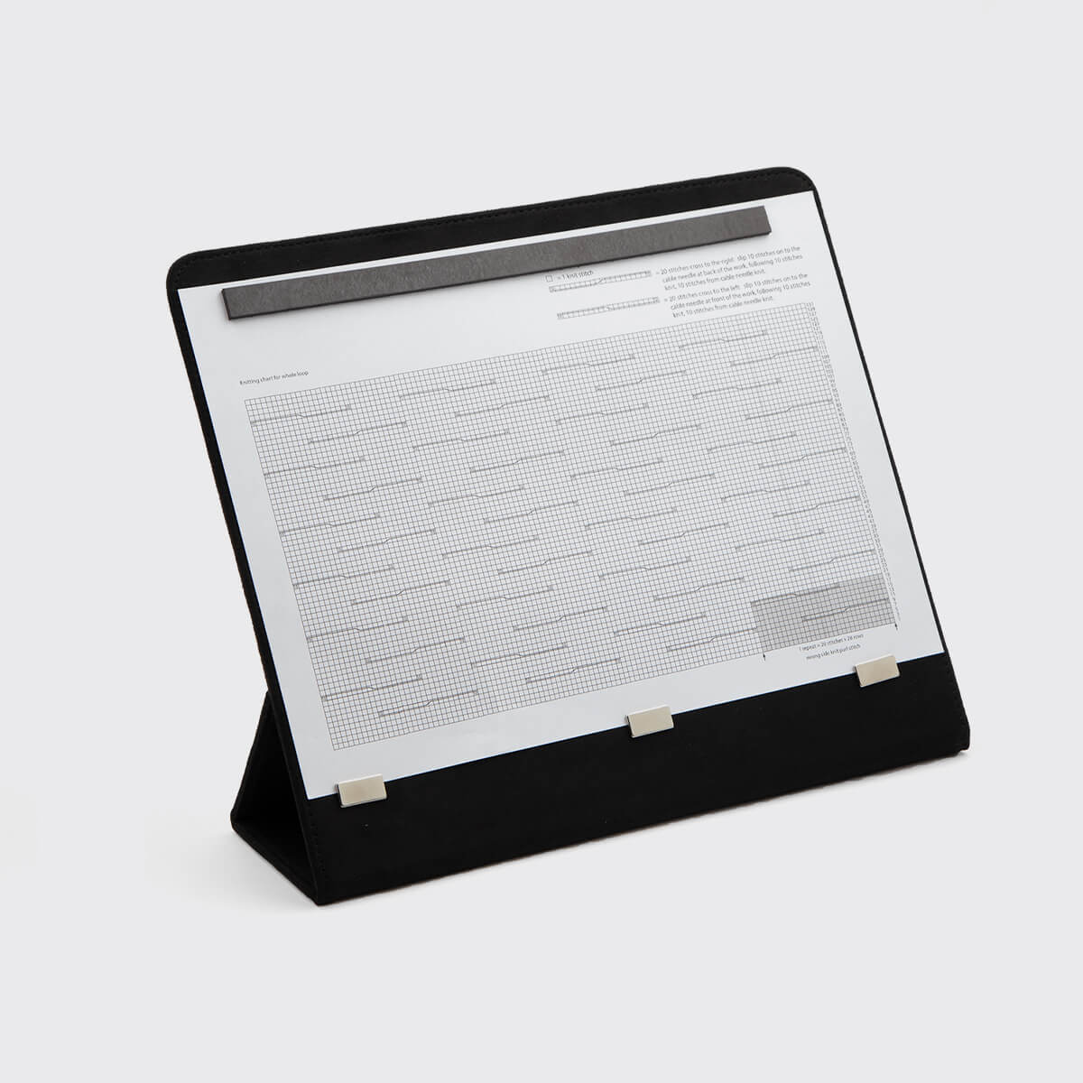 Suporte para documentos preto com clips metálicos e folha de papel