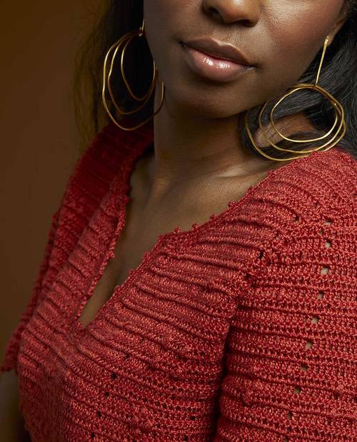 Camisola vermelha em malha com decote em V e brincos dourados grandes