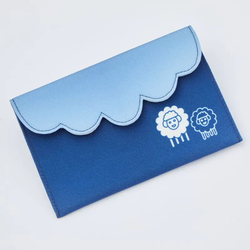 Carteira azul com desenhos de carneirinhos numa superfície branca