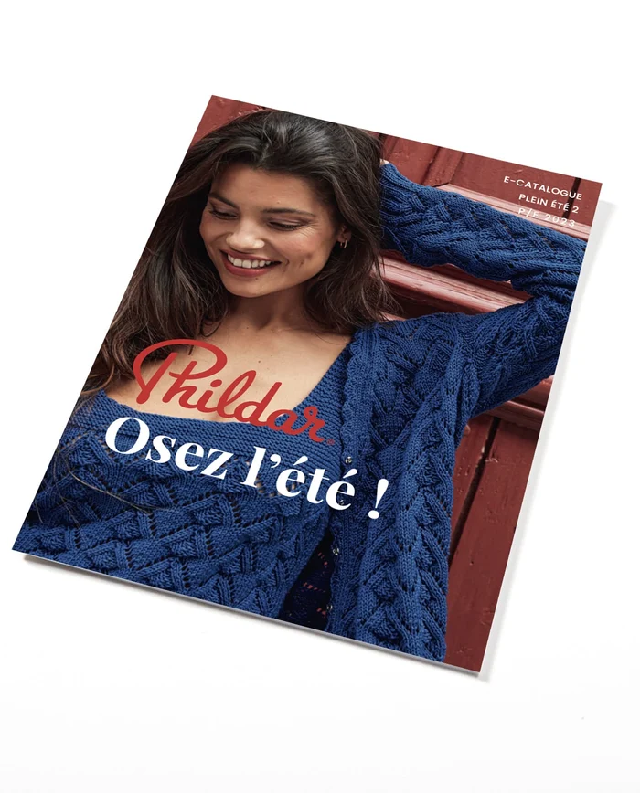 Catálogo Phildar com mulher usando casaco azul de malha trançada