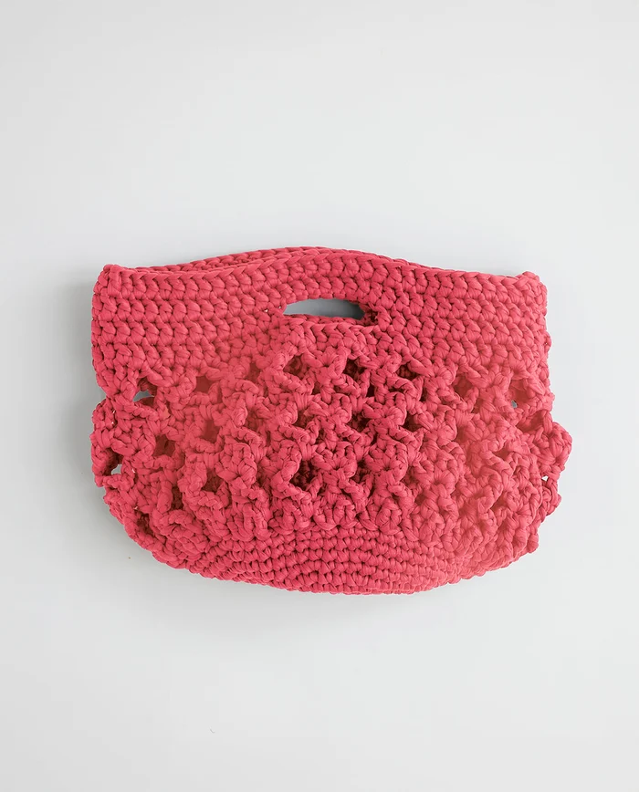 Mala de mão vermelha com padrão trançado e alça integrada