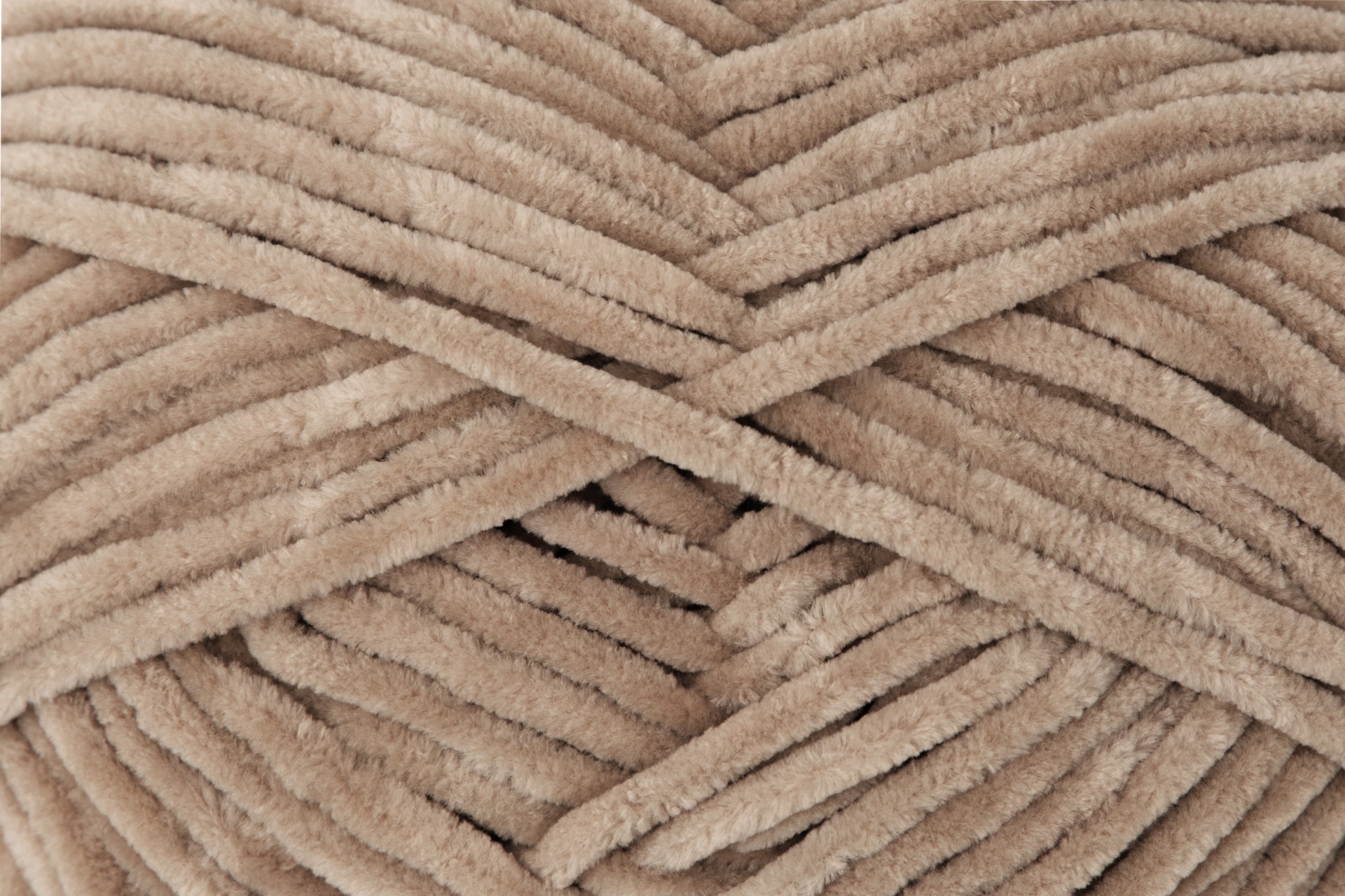 Fios de lã ou veludo grosso bege entrelaçados com textura felpuda.