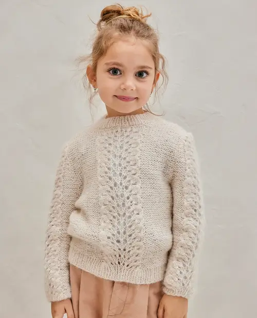 Criança com camisola bege de malha e calças cor de rosa claro