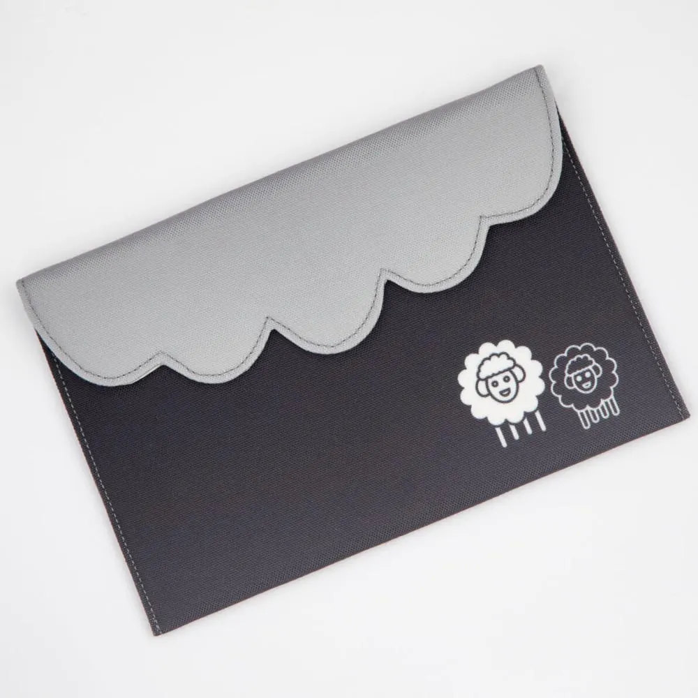 Envelope/capa preta com aba cinzenta ondulada e desenhos de duas ovelhas brancas
