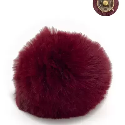 Pom-pom de pelúcia bordô com botão metálico dourado