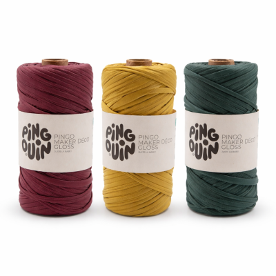 Três rolos de fio grosso em bordeaux, amarelo mostarda e verde escuro com etiquetas de papel branco da marca PINGOUIN.