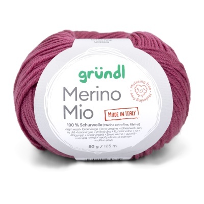 Novelo de lã merino extra fina cor magenta com etiqueta branca e texto em várias línguas.