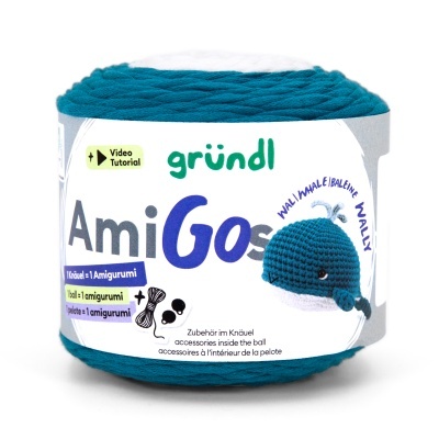 Rolo de fio de lã azul e branco com etiqueta de papel com texto e desenho de baleia amigurumi.