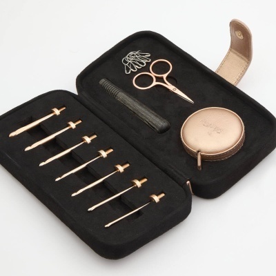 conjunto de ferramentas de costura com agulhas, tesoura, mini pente e alfinetes em estojo preto e dourado