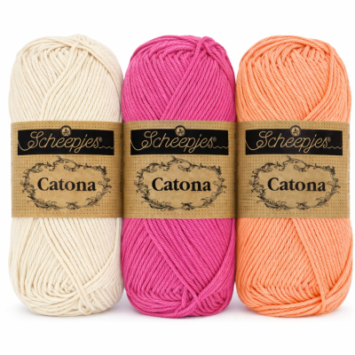 Três novelos de lã Scheepjes Catona em bege, rosa e laranja