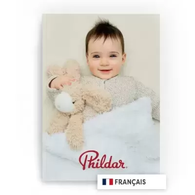 Bebé sorridente com camisola bege segurando peluche, manta branca, texto Phildar e selo Francês