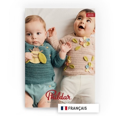 Dois bebés com camisolas de croché coloridas numa capa de revista.