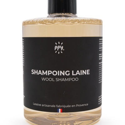 Frasco de champô para lã com rótulo preto e líquido amarelo claro