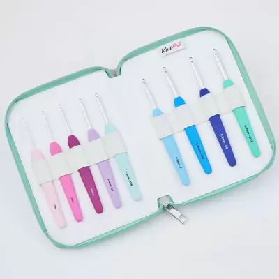 Conjunto de agulhas de croché coloridas numa bolsa branca com bordas verdes